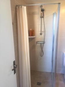 eine Dusche mit Glastür im Badezimmer in der Unterkunft Magnifique Studio in Sète