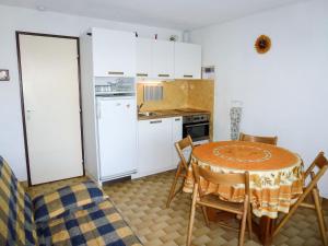 a kitchen with a table and a kitchen with white cabinets at Studio La Lagune by Interhome in Le Grau-du-Roi