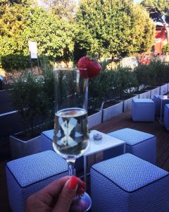 una persona che tiene in mano un bicchiere d'acqua con una fragola dentro di Hotel Rombino a Fonteblanda