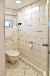ein weißes Bad mit einem WC und einer Dusche in der Unterkunft Annis Wohnschlösschen in Mainhausen