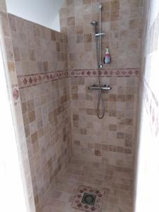 een badkamer met een douche en een tegelvloer bij L'Tas De Cailloux in Cancale