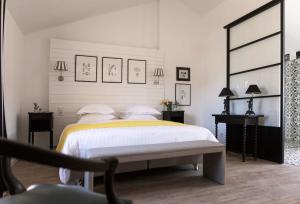 a bedroom with a bed and two tables and a chair at Les Jardins De La Livrée in Villeneuve-lès-Avignon