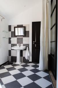 a bathroom with a sink and a checkered floor at Les Jardins De La Livrée in Villeneuve-lès-Avignon