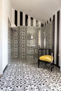 a bathroom with a black and white patterned wall at Les Jardins De La Livrée in Villeneuve-lès-Avignon