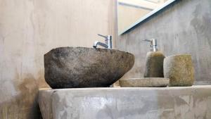 um lavatório de pedra com três torneiras na parede em Viva Mare Traditional Studios em Astypalaia