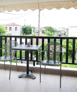 - Balcón con mesa y 2 sillas en Yannis Apartments, en Afitos