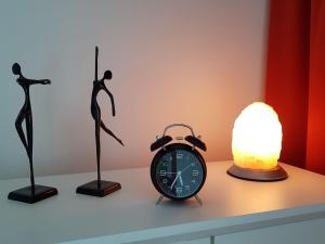 a table with a clock and a lamp on it at Apartment Abendrot in Sankt Englmar