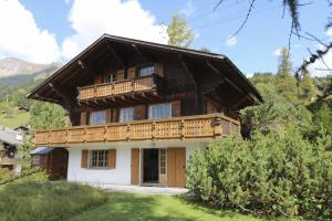 a large wooden house with a balcony on it at Rose de Noël in Les Diablerets