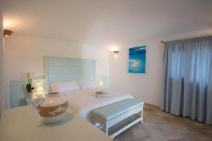 a bedroom with a bed and a vase on a table at Hotel Nibaru in Porto Cervo