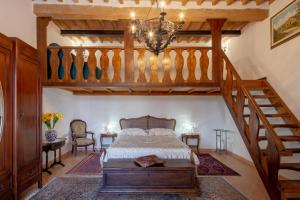 una camera con letto e scala in legno di Appartamento stile toscano in Fauglia a Fauglia