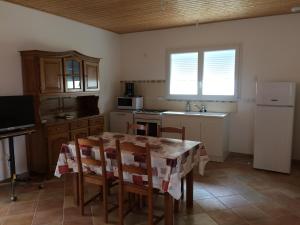 a kitchen with a table and chairs and a refrigerator at Maisons de vacances à Curzon in Curzon