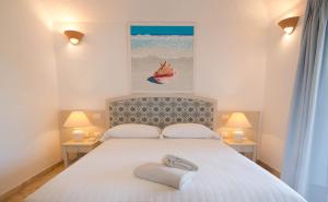 a bedroom with a bed with two towels on it at Hotel Nibaru in Porto Cervo