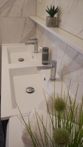 a white sink in a bathroom with a plant at Apartments Beautiful View in Omiš