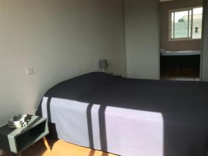 a bedroom with a bed with a black and white blanket at Appartement à la mer in Le Grau-dʼAgde