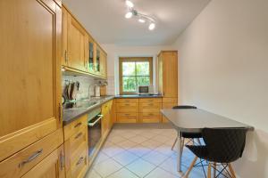a kitchen with wooden cabinets and a table and chairs at Rettenberger Murmele in Rettenberg