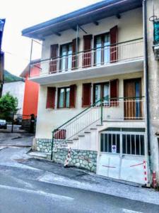 un bâtiment avec un balcon et des escaliers dans une rue dans l'établissement Casa Bianca, à Frabosa Sottana