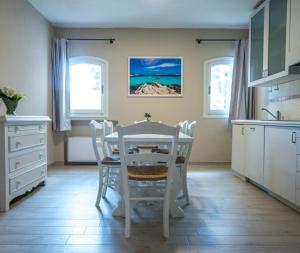 a kitchen with a white table and chairs at Hotel Nibaru in Porto Cervo