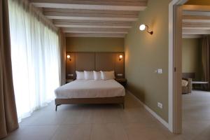 a bedroom with a bed and a large window at Le Greghe Suites in Lazise