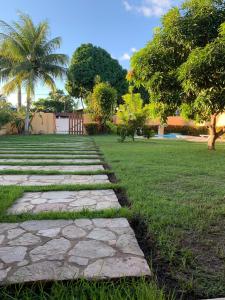 a garden with a stone path in the grass at Casa na Praia - Parkrio Sauaçuhy - Maceió - AL in Maceió