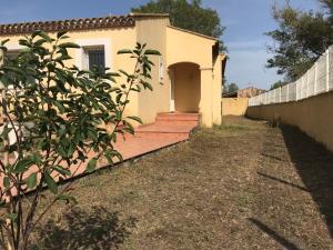 una casa con una valla al lado de un patio en Appartement à la mer, en Le Grau d'Agde