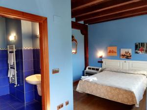 Dormitorio azul con cama y lavamanos en EcoHotel Rural Angiz en Busturia