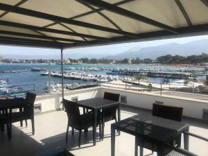un balcone con tavoli, sedie e un porto turistico di b&b Simpaty a Mondello