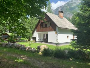 a small white house with a roof at Villa Ukanc in Bohinj