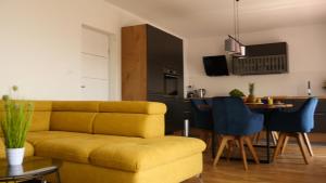 a living room with a yellow couch and a table at Apartments Beautiful View in Omiš