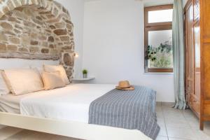 sypialnia z łóżkiem z kamienną ścianą w obiekcie My Vintage Home - Naxos w miejscowości Agios Prokopios