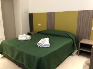 a bedroom with two towels on a green bed at B&B Maison D'Art in Sorrento