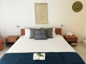 1 dormitorio con 1 cama blanca grande y 2 mesas en Apartments Off, en Supetar