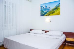 a bedroom with a bed with white sheets and a window at Nehaj in Senj