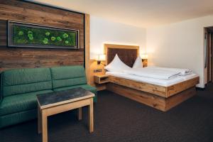 une chambre d'hôtel avec un lit et un canapé dans l'établissement Hotel Barbara, à Serfaus