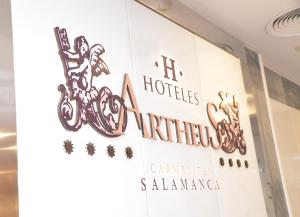Una señal para un hotel con una motocicleta. en Artheus Carmelitas Salamanca, en Salamanca