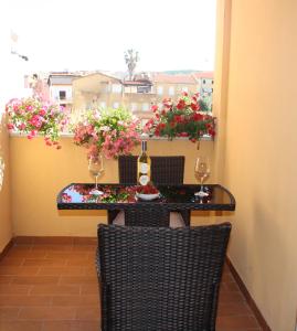 a table and chairs on a balcony with flowers at Appartamenti Sole 1 in Alghero