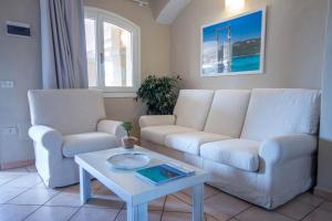 a living room with two white couches and a table at Hotel Nibaru in Porto Cervo