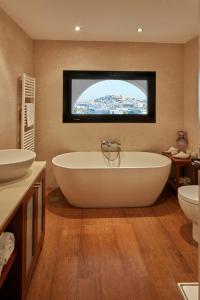 bagno con vasca, 2 lavandini e TV di Bab el Oued Villa Ibiza a Puig D’en Valls