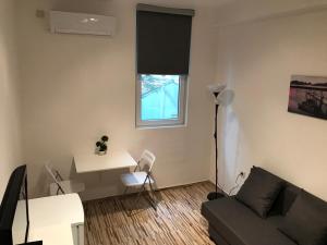 a living room with a couch and a table and a window at Студио Чайка Бургас Център in Burgas City