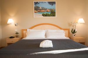 a bedroom with a large bed and two lamps at Hotel Nibaru in Porto Cervo