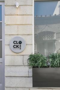 a sign for a clo clinic on the side of a building at Clock Wise Syros in Ermoupoli