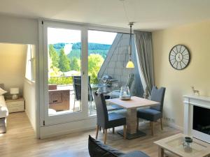 a living room with a table and a dining room with a window at Schöne Bergsicht in Hahnenklee-Bockswiese