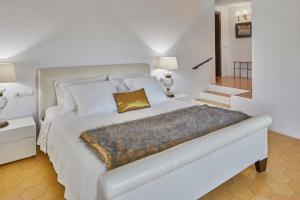 ein Schlafzimmer mit einem großen weißen Bett und einem goldenen Kissen in der Unterkunft Bab el Oued Villa Ibiza in Puig D’en Valls + 32 Fotos