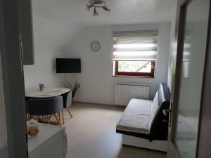 a small living room with a table and a window at Apartman Laura in Smoljanac