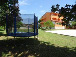 a blue trampoline in the grass in front of a building at Apartments Orange Medulin in Medulin