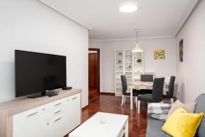 una sala de estar con TV de pantalla plana en una cómoda en Arena en Perlora, en Gijón