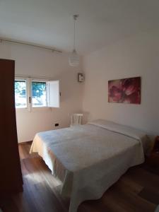 sypialnia z łóżkiem w białym pokoju w obiekcie Casa vacanza nel cuore del Salento w mieście Parabita