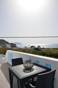 a table and chairs on a balcony with the ocean at Palaiokastro view in Karpathos Town