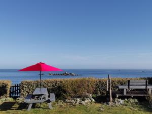 a picnic table and an umbrella on the beach at Das Haus auf der Düne in Plouescat