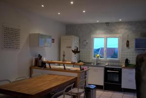 a kitchen with a wooden table and a counter top at Das Haus auf der Düne in Plouescat