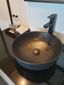 La salle de bains est pourvue d'un lavabo en bronze et d'un miroir. dans l'établissement Mayson Place Hotel, à Ban Phraek Sa